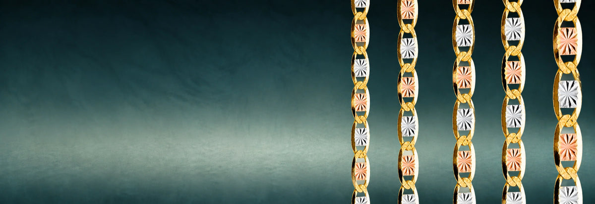 Tri-color gold Valentino link chains on a dark teal background