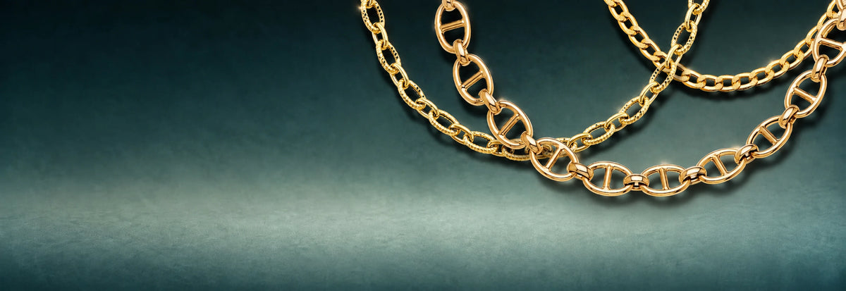 Yellow gold Mariner link bracelets and chains on a teal background